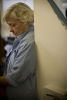 A woman looking down in a hallway.